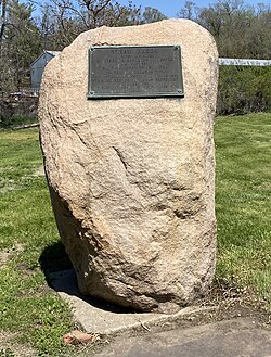 Plaque inset in a large, beige stone