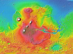 MOLA colorized shaded-relief map of western hemisphere of Mars showing Tharsis bulge (shades of red and brown). Tall volcanoes appear white.