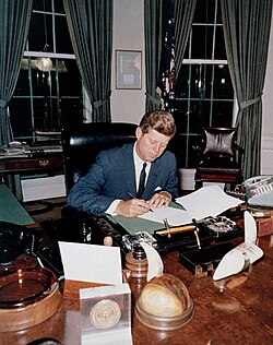 Kennedy signs the Proclamation for Interdiction of the Delivery of Offensive Weapons to Cuba in the Oval Office; c. October 23, 1962