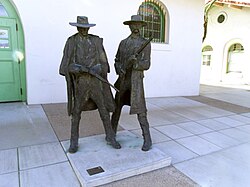 This statue built on March 25, 2005, depicts Earp and Holliday on the location of the 1880s Tucson Depot where Frank Stilwell was killed by Earp. It is now part of the Amtrak Station.